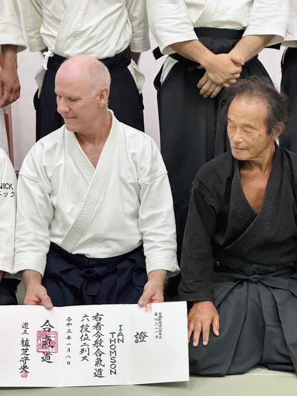 Ian Thomson Sensei with his 6th Dan certificate, beside Takayasu Sensei